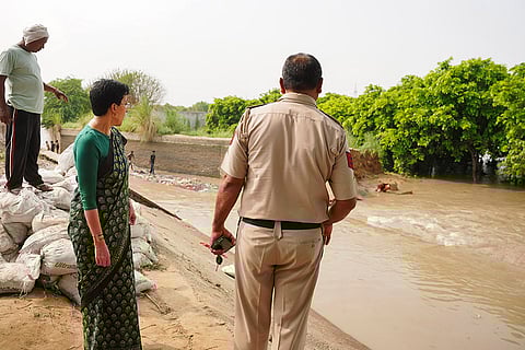 Atishi inspects a flooded area after a breach in Munak canal